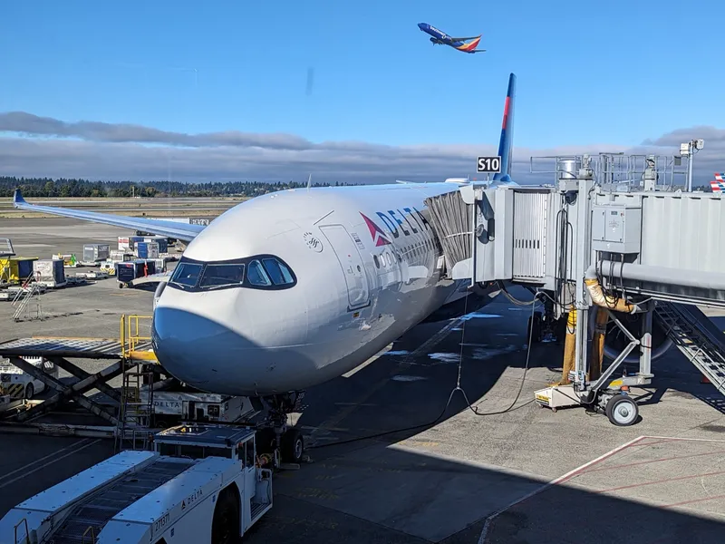 Plane at SeaTac Airport gate with blue sky and mountains in the background